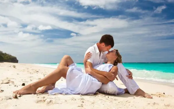 Couple lying on sand embracing