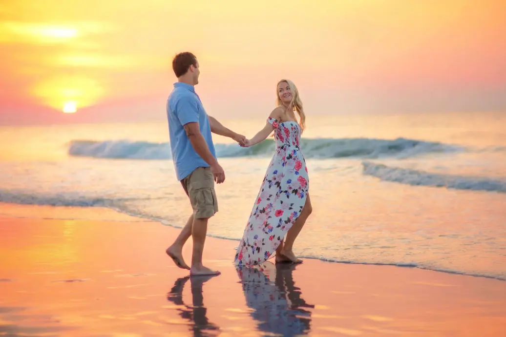 couple strolling on the beach at sunset
