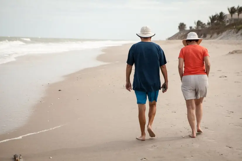 retired couple walking beach