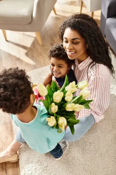 Two children present their Mother with flowers