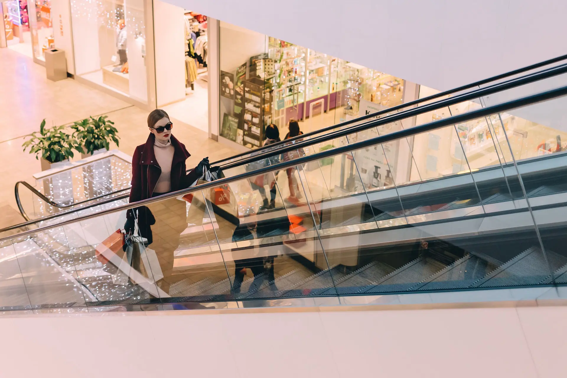 Lady riding escalator in shopping mall