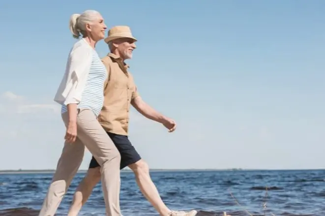 retired couple walking beach