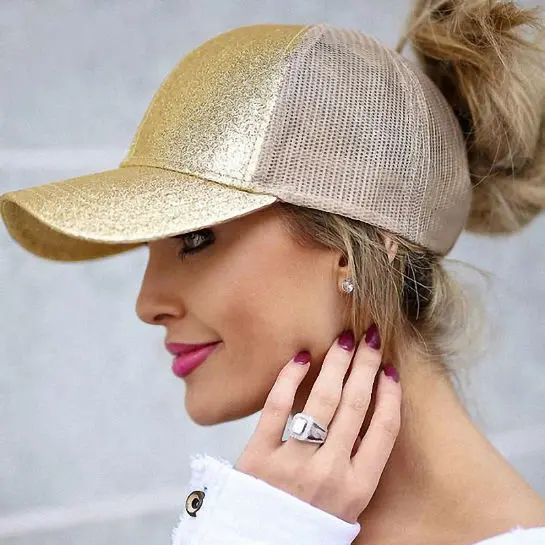 Woman wearing gold baseball hat